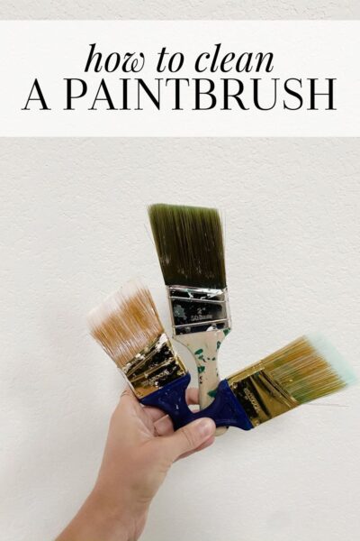 cleaning a paintbrush covered in wood stain with turpentine