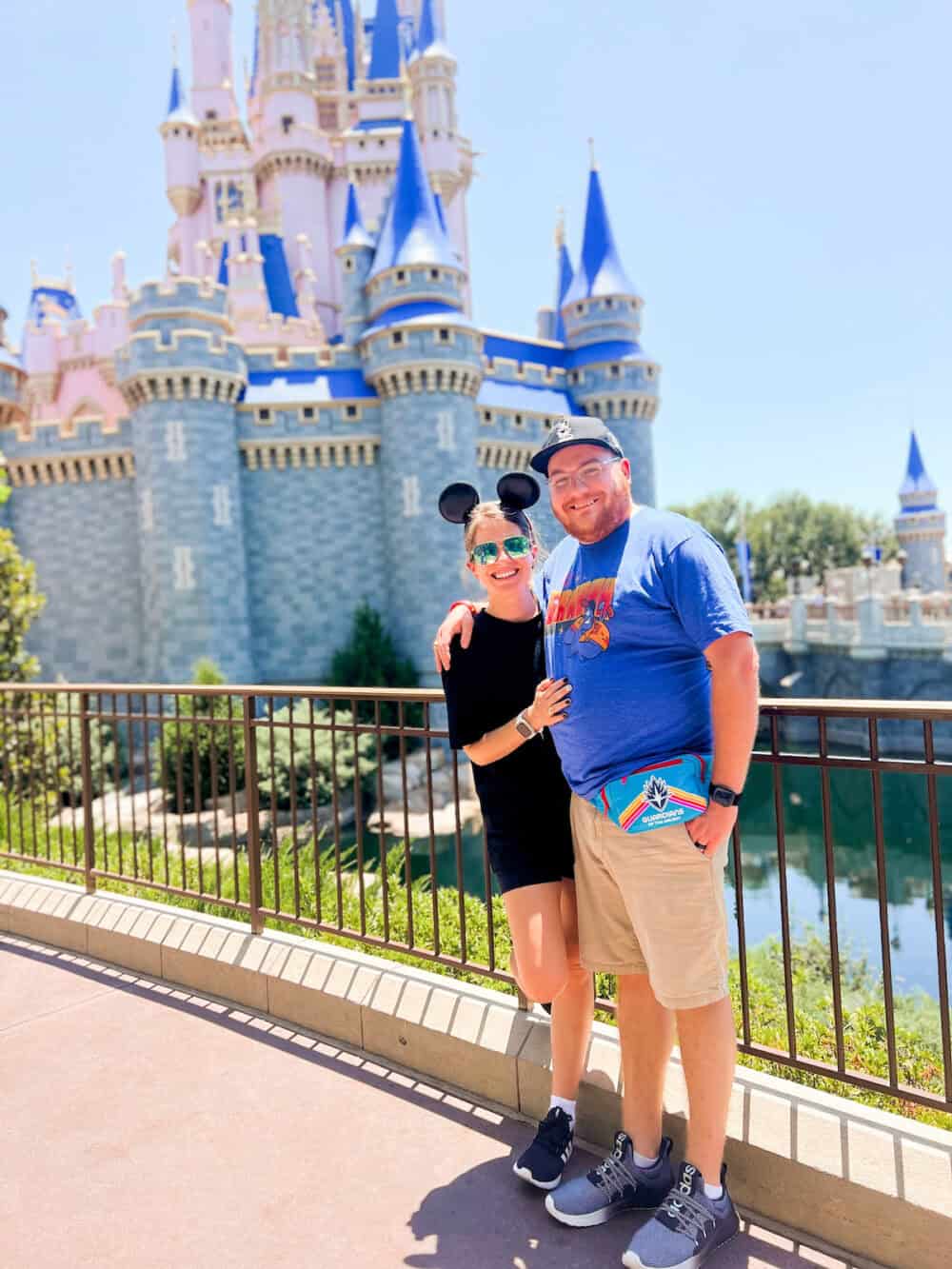 husband and wife posing in front of Cinderella's Castle in Walt Disney World