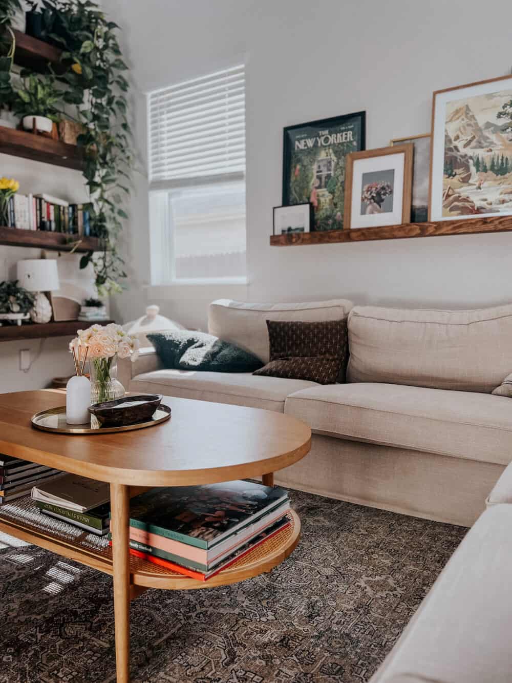 A living room with a wood coffee table and open shelving on the wall 