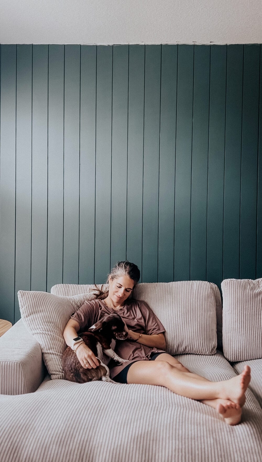 woman cuddling with a small dog on a white sofa