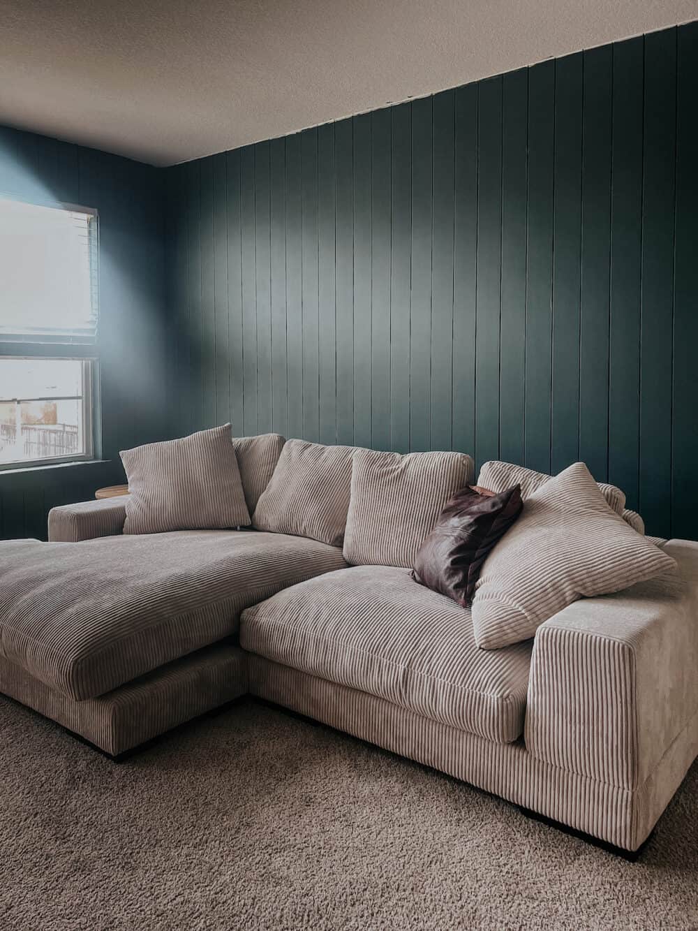 a family room with green shiplap on the walls 