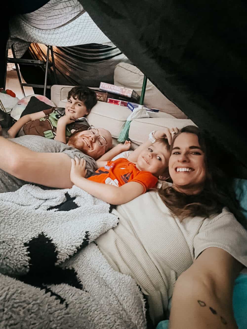 family in a living room tent for an indoor campout 