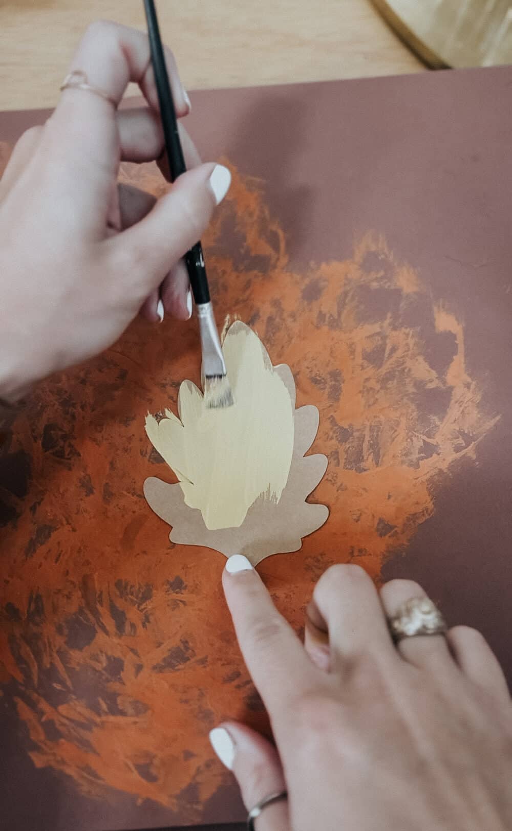 hand painting a paper leaf