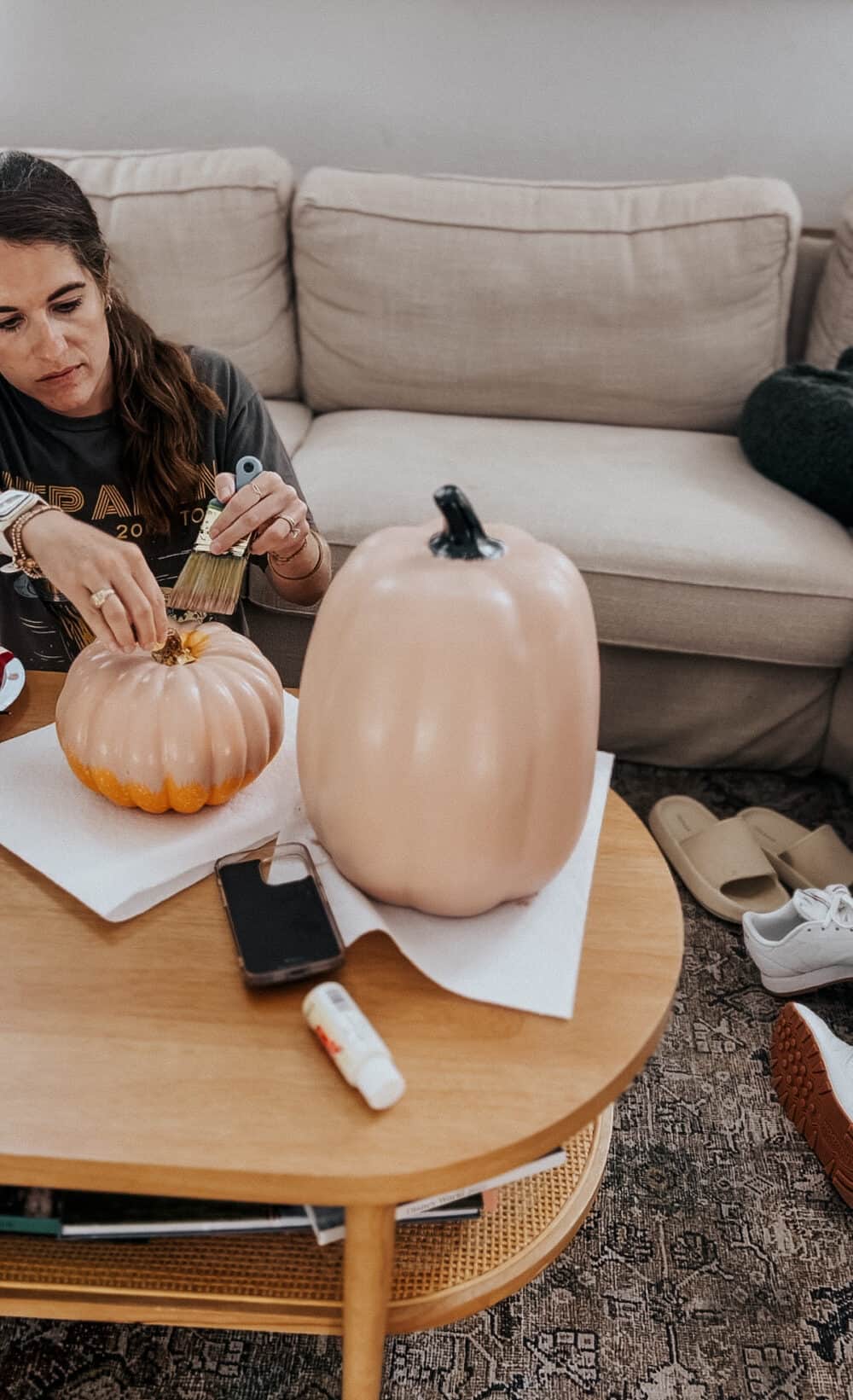 woman painting diy faux terra cotta pumpkins 