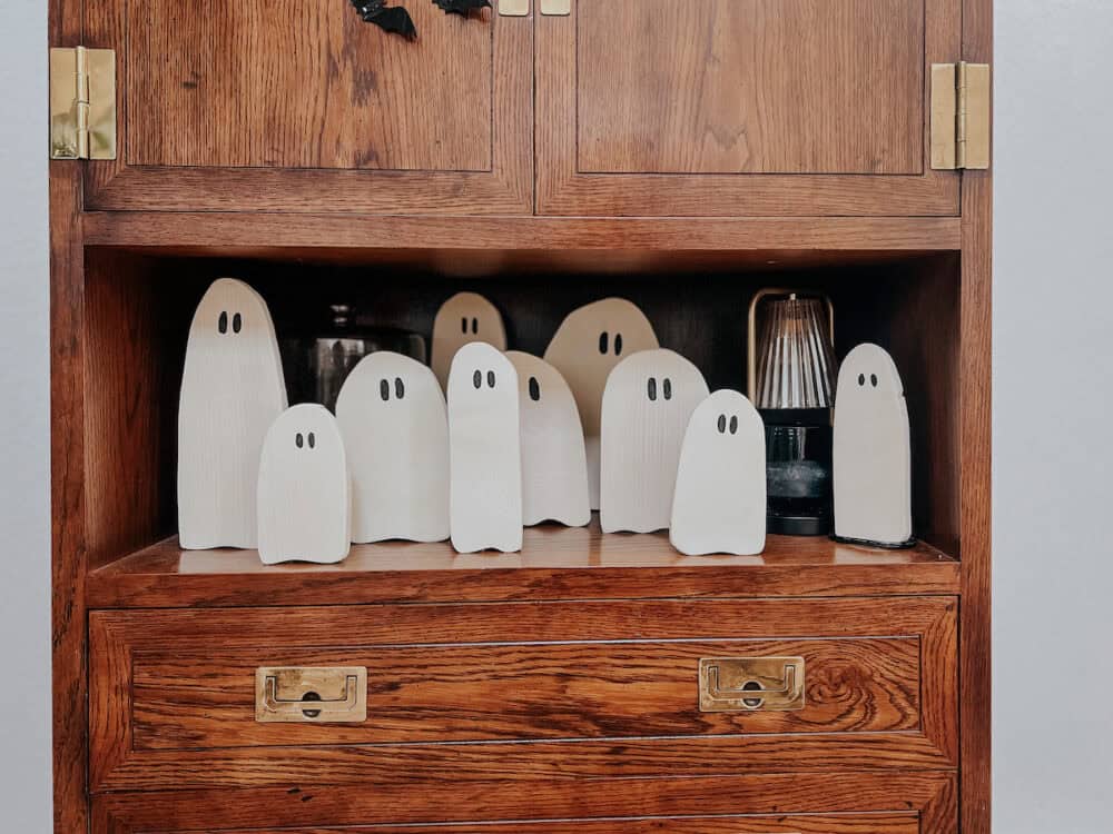 a collection of adorable DIY wood ghosts sitting on a shelf