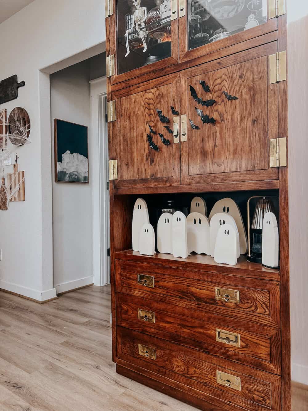 a charming collection of DIY wood ghosts on a bar cabinet 