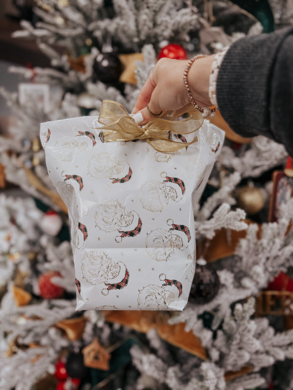 woman's hand holding a gift wrapped in a diy gift bag