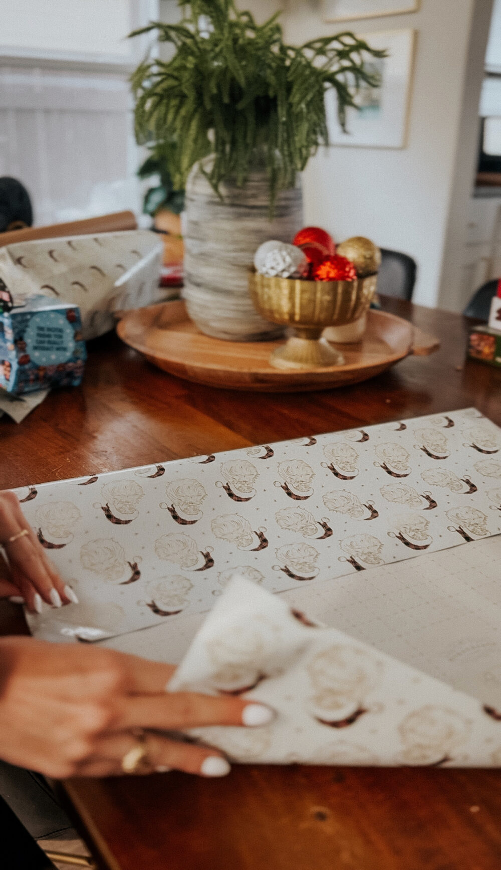 woman folding wrapping paper to create a gift bag